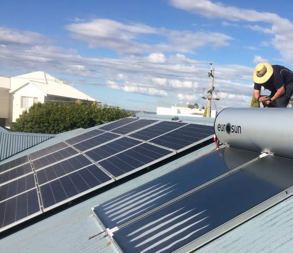 Solar Hot Water 23 Solar panel installation: Rooftop solar system with worker installing Eurosun solar water heater. Finance your solar project today.